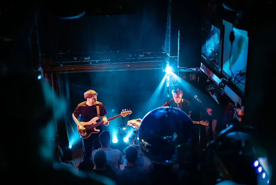 Band auf der Bühne in blauem Licht, Bassist vorne – ENL & Dachs live im Salzhaus Winterthur, 2025