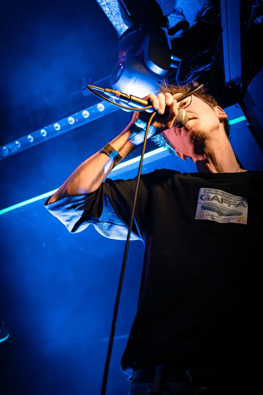 Sänger singt mit erhobenem Kopf ins Mikrofon, blaues Licht – ENL & Dachs live im Salzhaus Winterthur, 2025