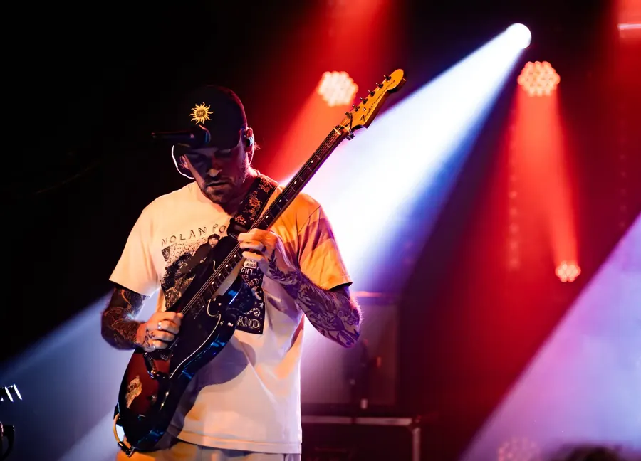 Gitarrist mit Cap spielt E-Gitarre in rotem und weissem Licht – Fomies live im Salzhaus Winterthur, 2025