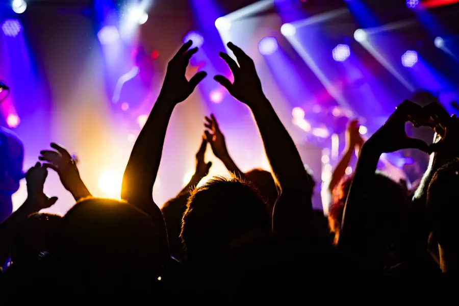 Publikum mit erhobenen Händen und Herzzeichen in violettem Licht – Fomies live im Salzhaus Winterthur, 2025