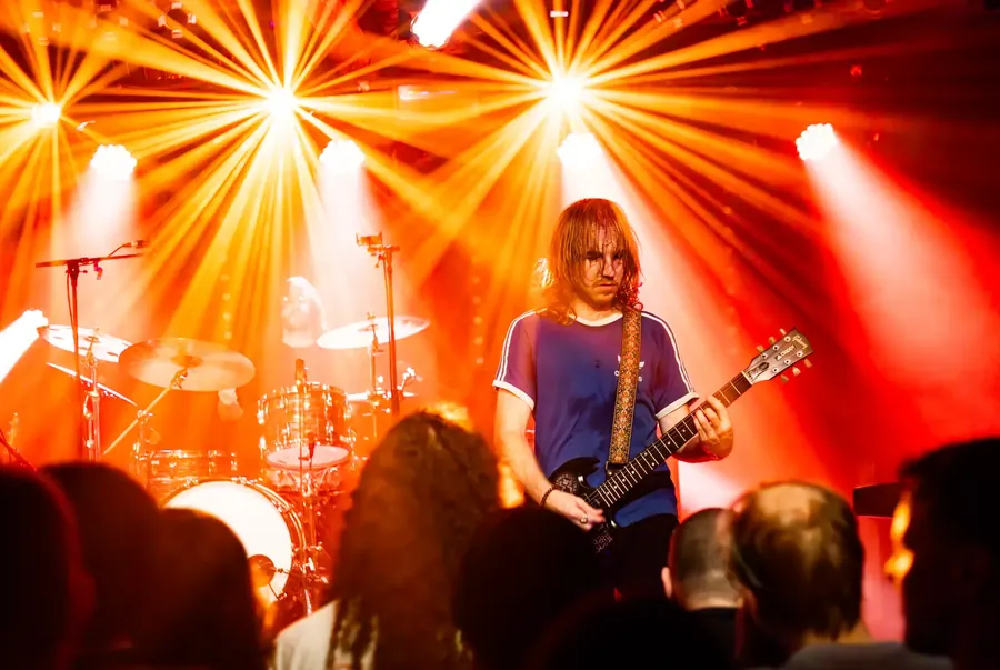 Langhaariger Gitarrist zwischen orangen Lichtstrahlen – Fomies live im Salzhaus Winterthur, 2025