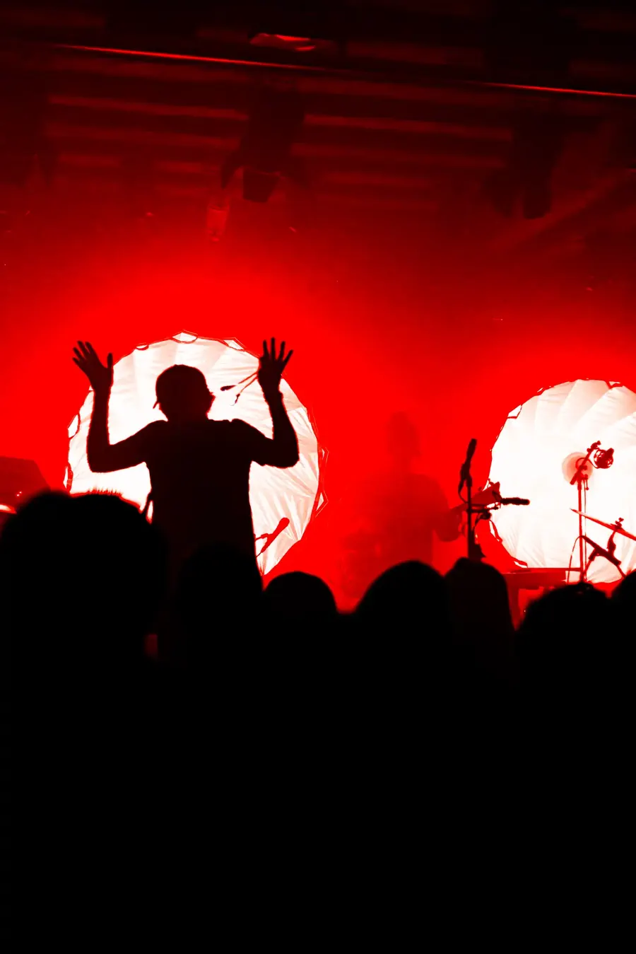Silhouette mit erhobenen Armen vor rotem Licht – Patrick Watson live im Salzhaus Winterthur, 2025