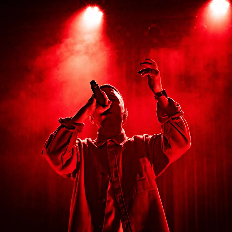 Rapper mit Mikrofon und erhobenem Arm in rotem Licht – Soukey & Stereo Luchs live im Salzhaus Winterthur, 2025