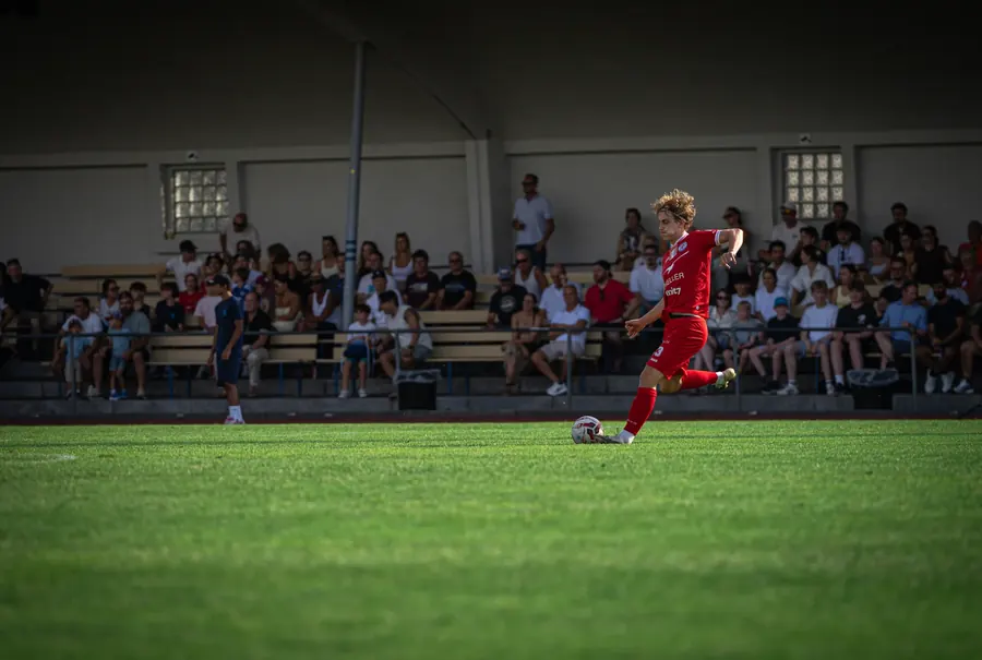 FCW-Spieler im roten Trikot schlägt einen langen Ball vor der vollen Tribüne – FC Winterthur im Cup-Spiel vom 15. August 2026