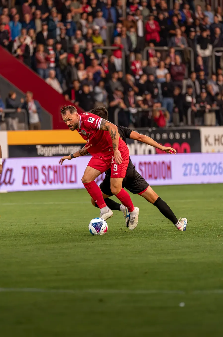 FCW-Spieler im Laufduell mit Ball vor voller Tribüne – FC Winterthur gegen FC Stade Lausanne-Ouchy auf der Schützenwiese, 29. August 2026
