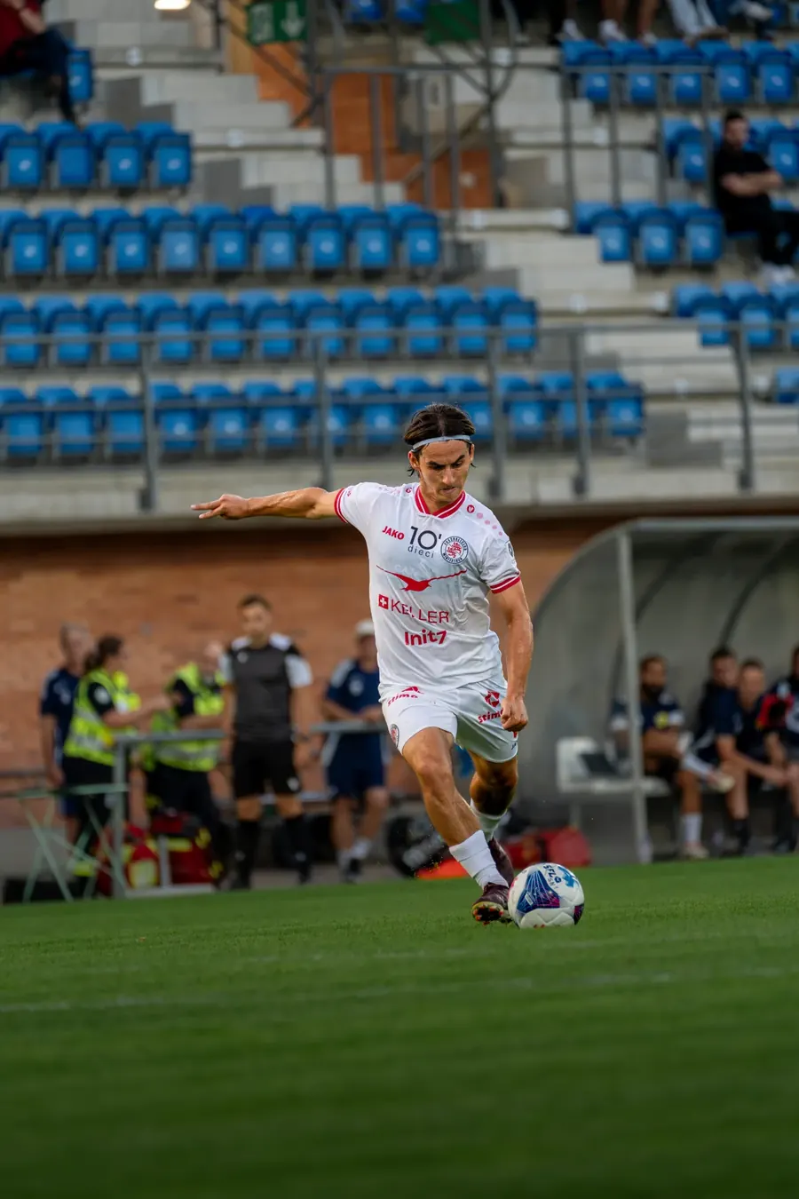 FCW-Spieler dribbelt vor der Tribüne mit blauen Sitzen – FC Stade Nyonnais gegen FC Winterthur, 1. September 2026