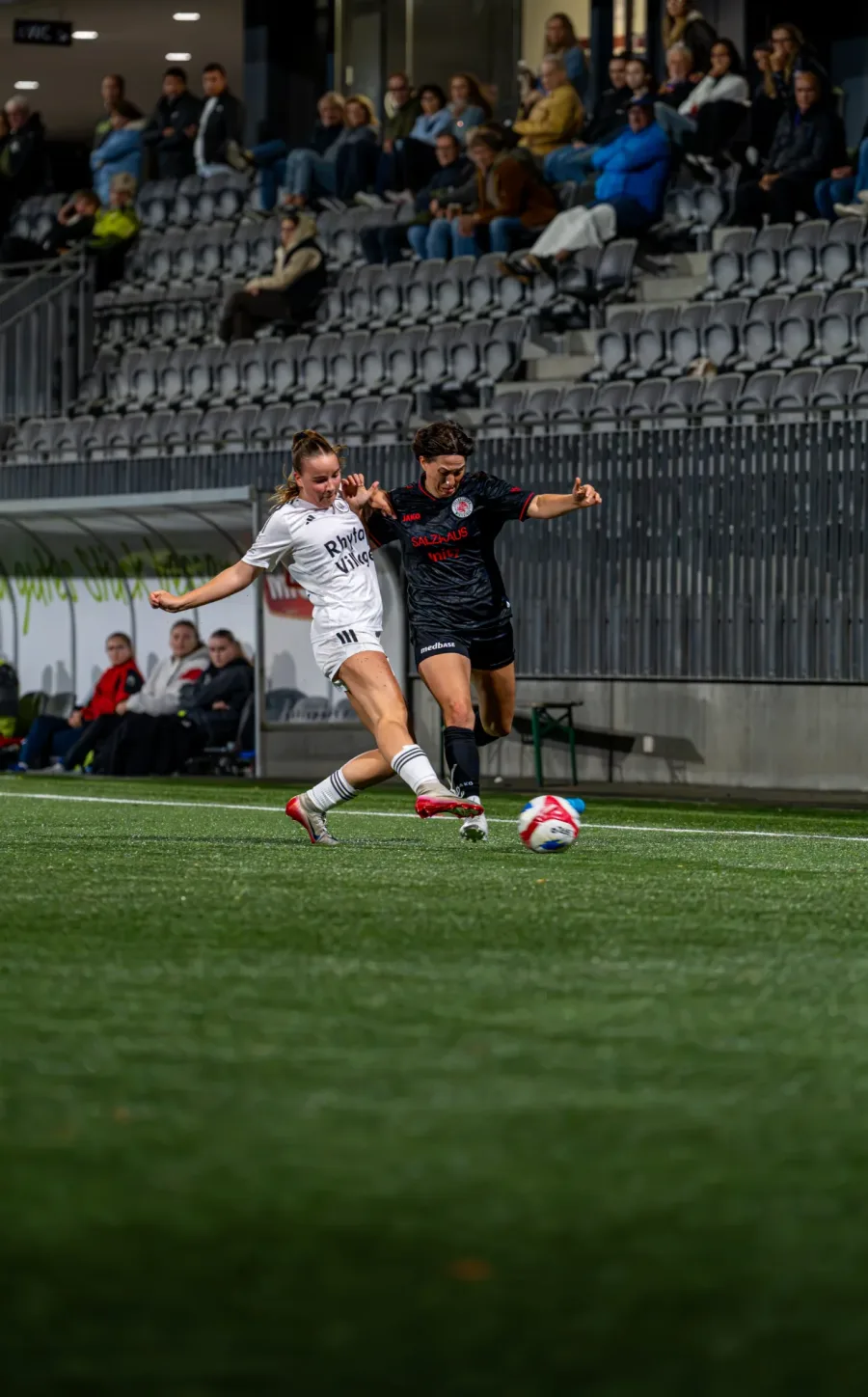 Zweikampf vor der Tribüne, FCW-Spielerin in Schwarz gegen Wil-Spielerin in Weiss – FC Wil gegen FC Winterthur Frauen, 9. September 2026
