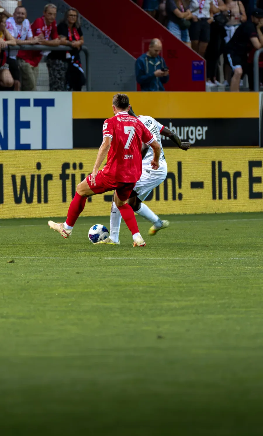 FCW-Spieler mit der Nummer 7 am Ball vor der Werbebande – FC Winterthur, Heimspiel auf der Schützenwiese